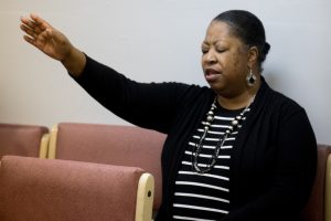 Debbie Spruell with hand raised in prayer at church