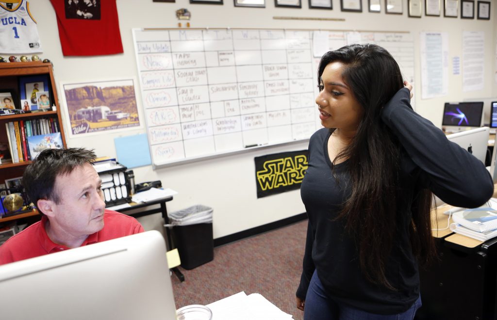 Journalism student Divya Murali talks to Journalism Teacher Brian Higgins about her weekly podcast featuring kids of different religions, genders and ethnicity for the student news site, Wingspan, at Liberty High School in Frisco. This longtime white district is quickly becoming more diverse. At Liberty High, a quarter of the kids are Asian. Ten percent are Hispanic; about the same number are black. Just under half are white. Photographed in Frisco, Texas on Friday, February 10, 2017. (photo © Lara Solt)