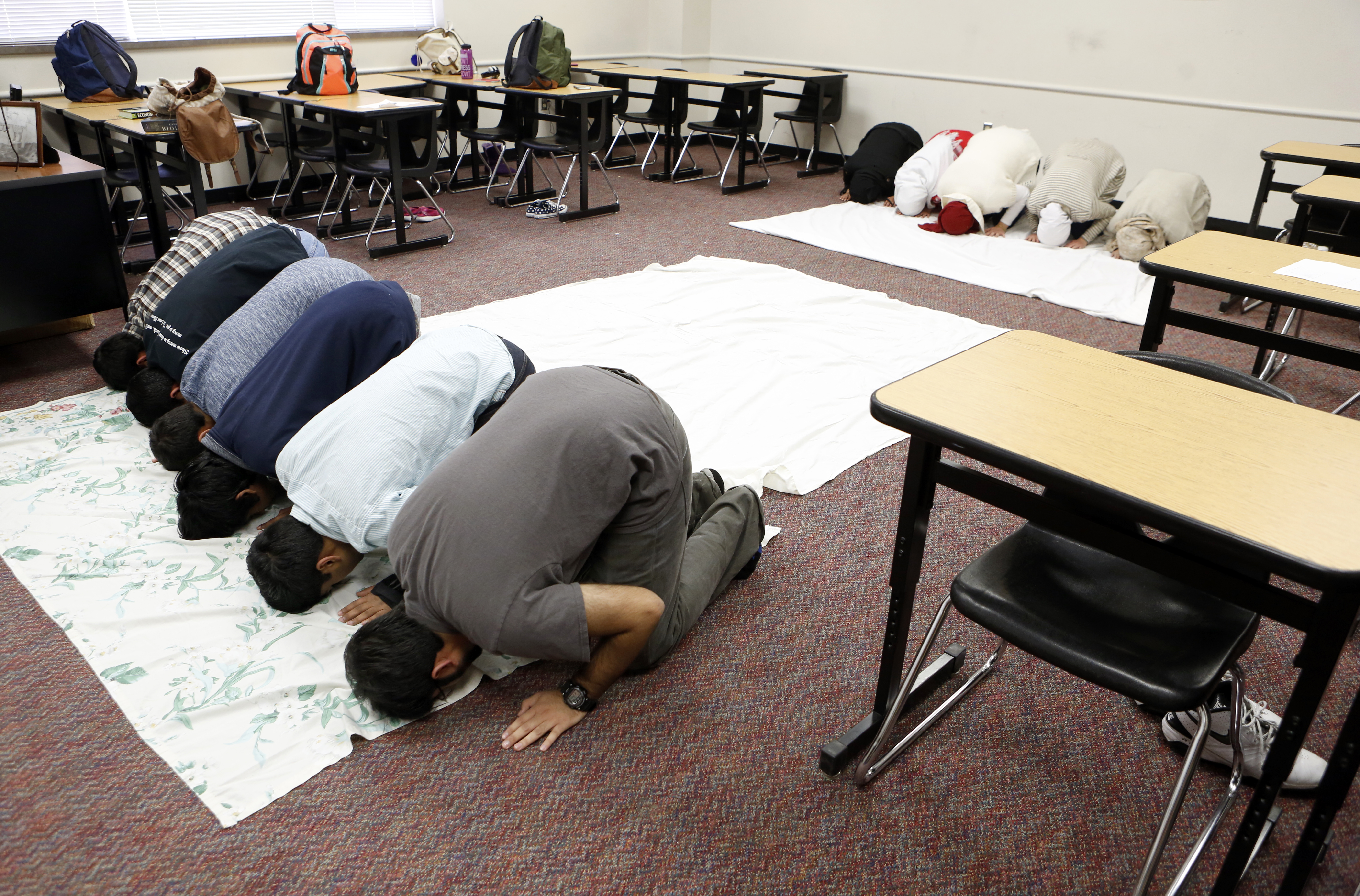 Muslim students gather to pray inside a classroom at Liberty High School in Frisco. This longtime white district is quickly becoming more diverse. At Liberty High, a quarter of the kids are Asian. Ten percent are Hispanic; about the same number are black. Just under half are white. Photographed in Frisco, Texas on Friday, February 10, 2017. (photo © Lara Solt)