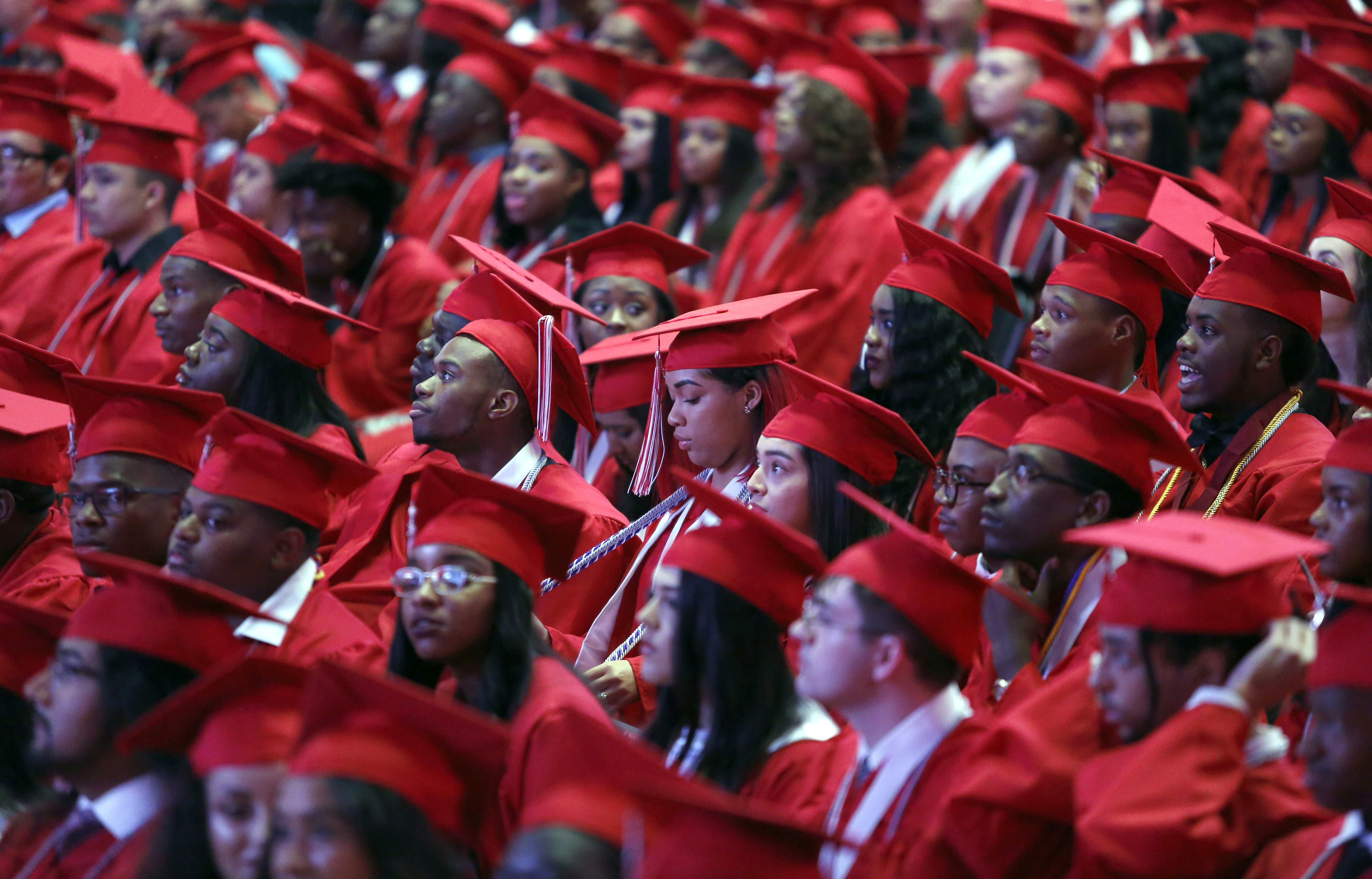 Surrounded by other graduates, Phantasia Chavers (center), adjusts her honor cords during her graduation from Cedar Hill High School at College Park Center in Arlington on Friday, May 26, 2017. (photo © Lara Solt)