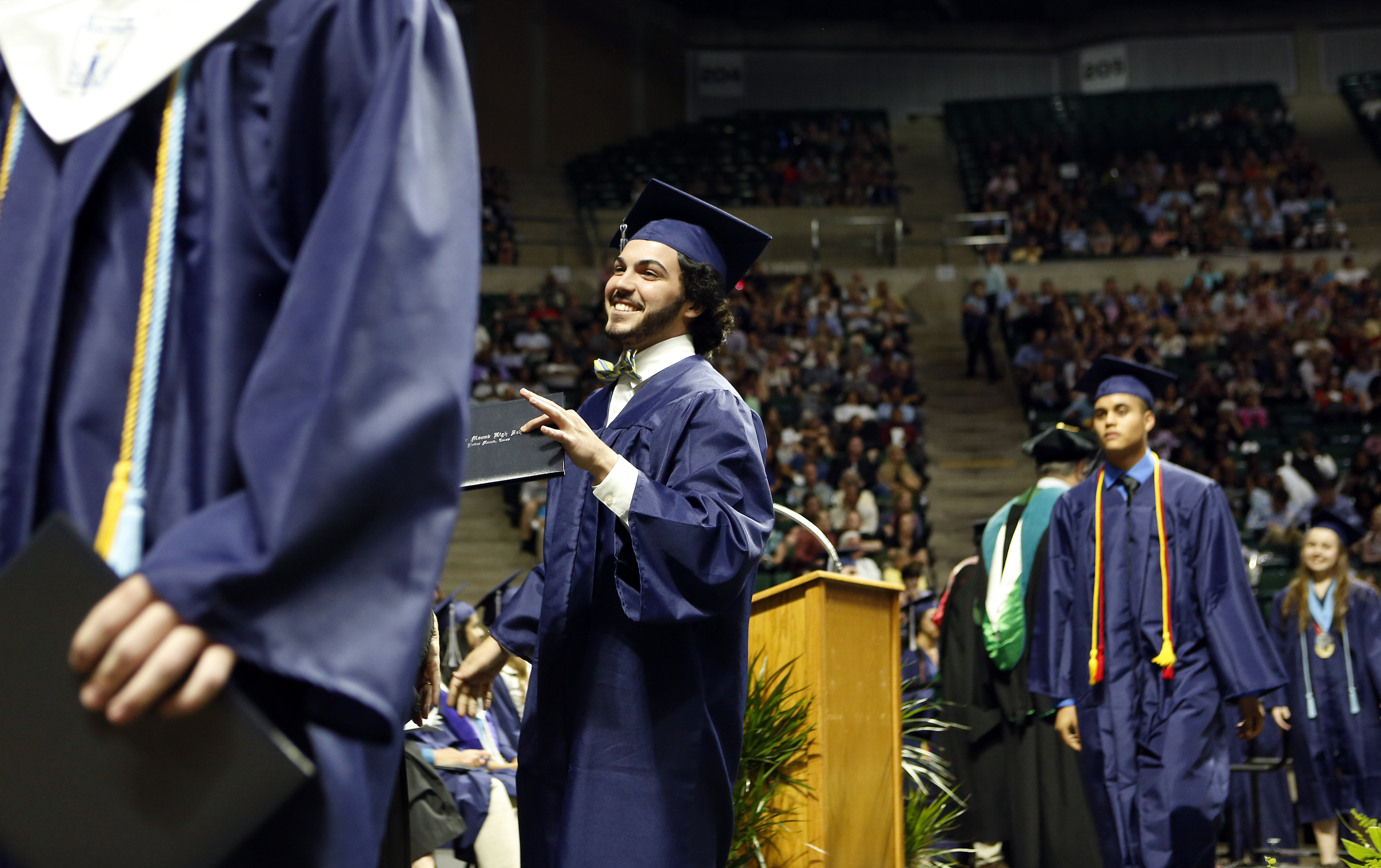 Ricky Rijos Jr. receives his diploma while walking the stage during his graduation from Flower Mound High School at UNT Coliseum in Denton, on Monday, June 6, 2017. (photo © Lara Solt)