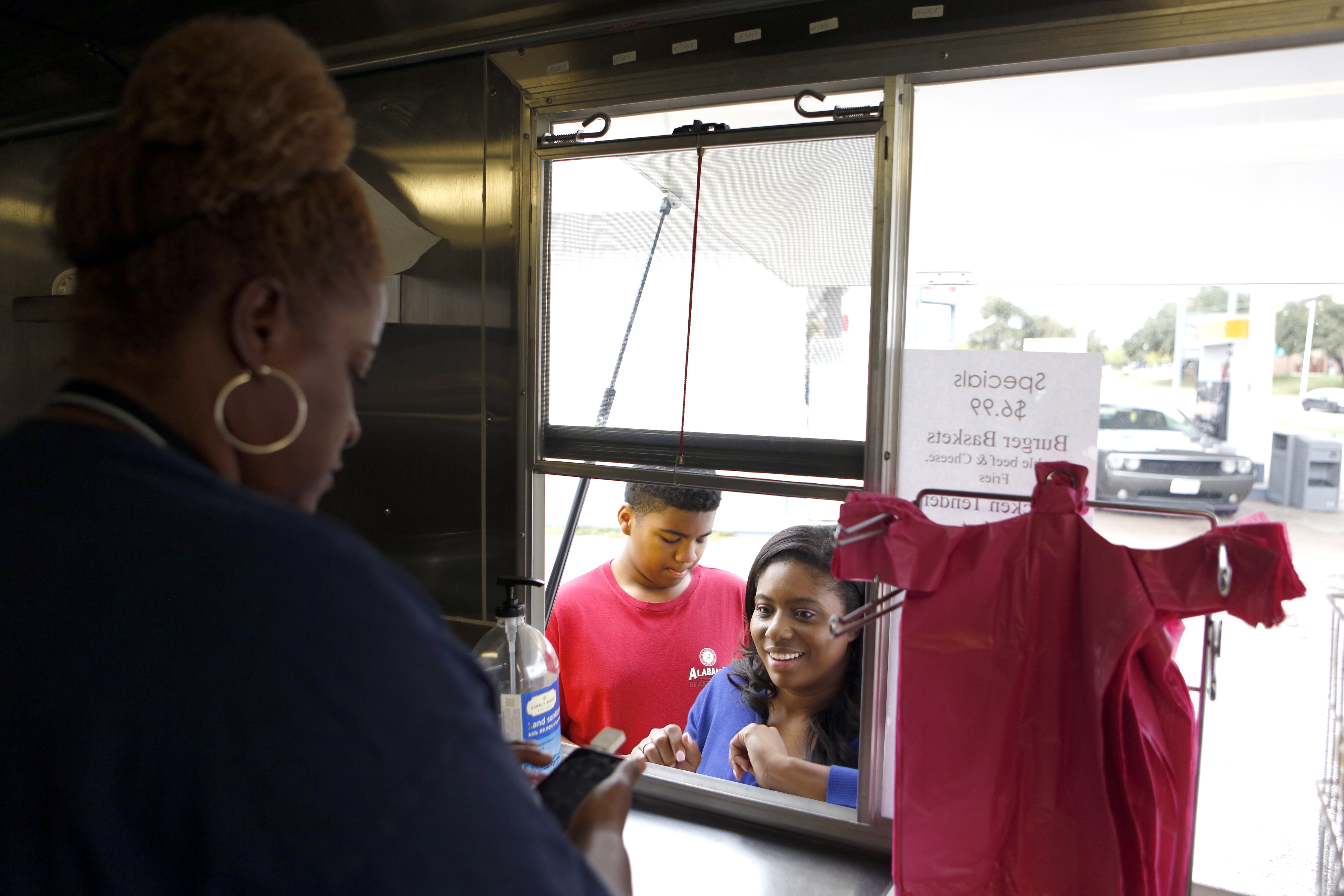 Customers Tara Hairston and son Tyler Kennedy, 14, place their orders at Quincy and Sheri Brown's food truck, Ain't No Mo! Butter Cakes, on their third day operating from a Shell gas station near 635 and Ferguson Rd in Garland, Texas. Photographed on Friday, November 6, 2015. Photo/Lara Solt