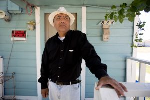 Joe Garcia on the front porch of his home where he lives with his 84-year-old mother on McBroom Street in West Dallas. Photo/Allison V. Smith