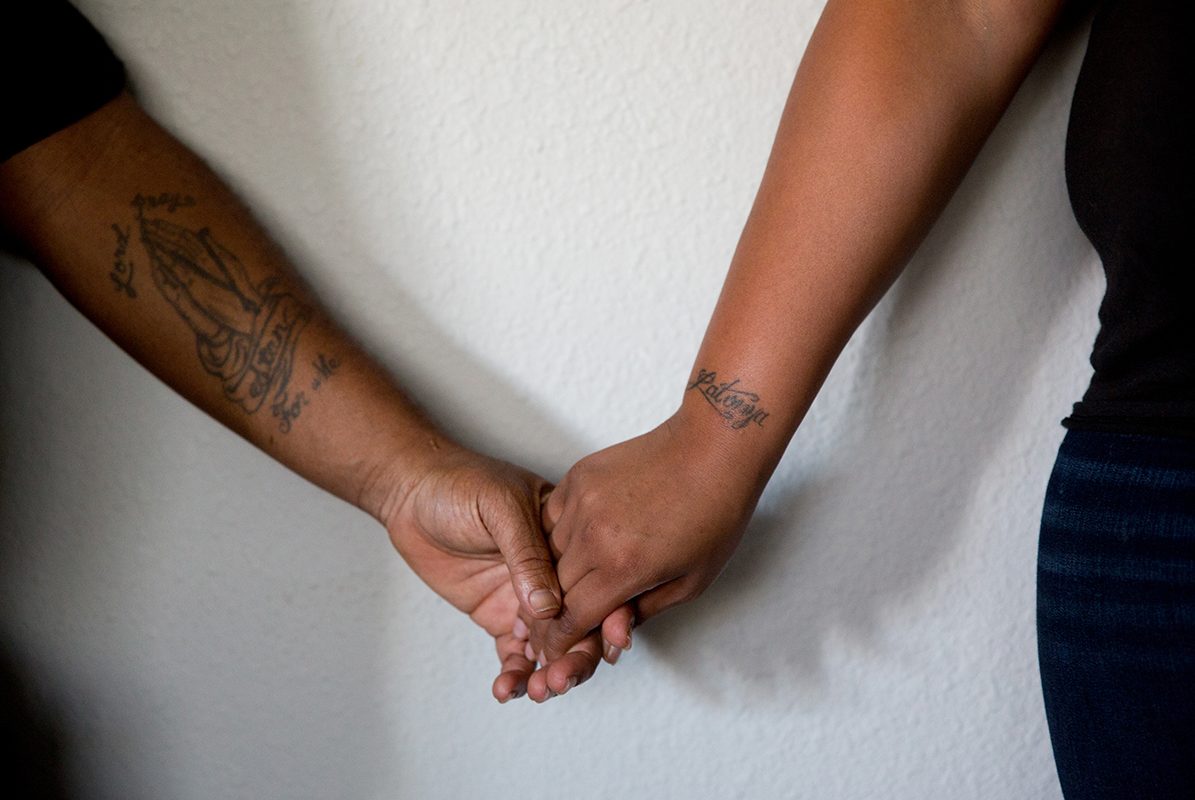 Stanley Walington, 38, and his girlfriend, Lynette Sherman, 24, hold hands in their apartment in Fort Worth. Walington was released from Bonham State Jail earlier this month.