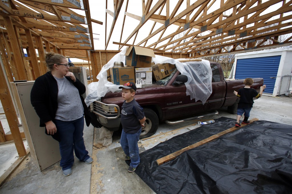 Jessica Cadick, and two of her children (from left) Joshua Tucker, 9, and Kaden Beck, 6, at their Garland home where they have already started rebuilding after their house was seriously damaged in the December tornadoes. Charles is a general contractor and lost his truck, which means he canÕt work. But since the landlord is rebuilding the damaged rental house, Charlie will be on that rebuilding team, which is a paying job. Photographed Sunday, February 21, 2016. (photo copyright Lara Solt)