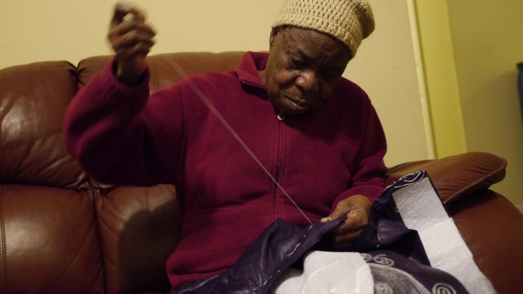 Nowai Gartay Korkoyah, Thomas Eric Duncan's mother, needles a traditional Liberian cloth called a lapa. Photo: Doualy Xaykaothao, KERA News 